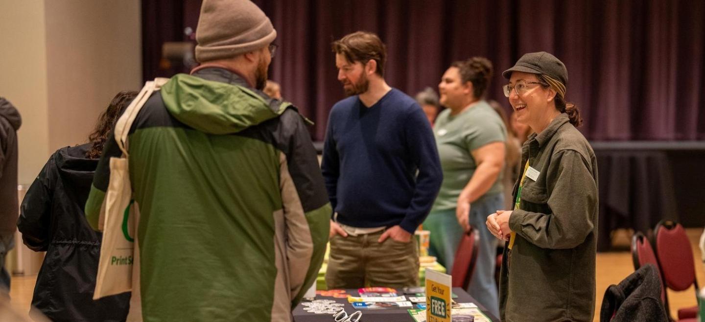 Several employees happily chatting at the employee resource fair