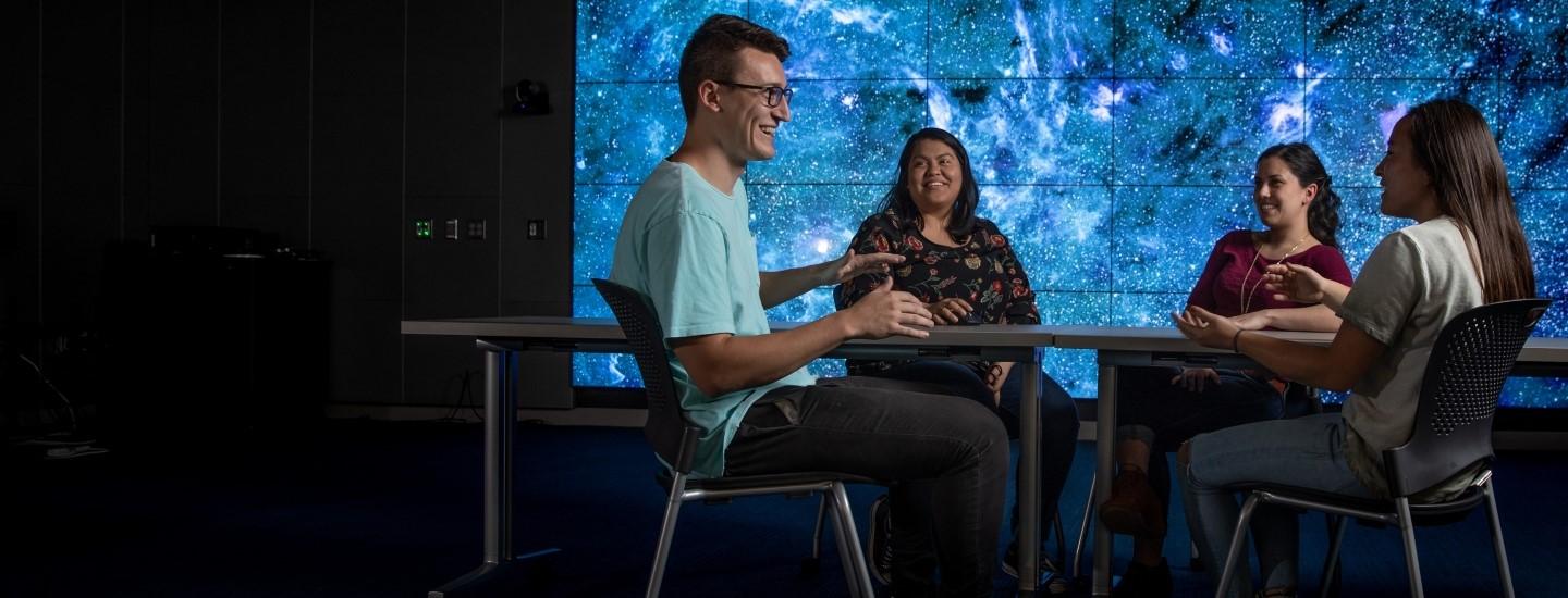 employees talking in front of digital display