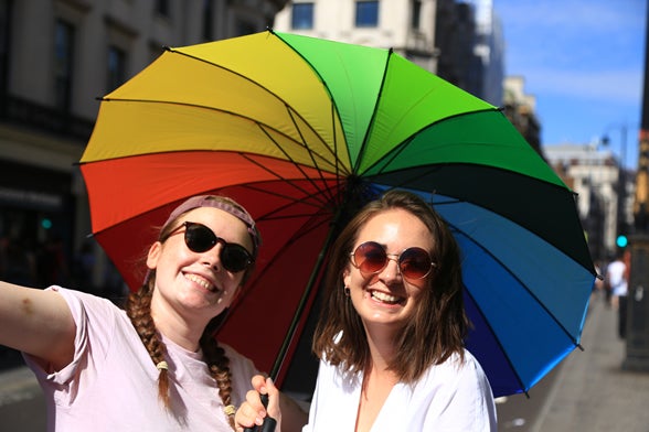 two women under a colorful umbrella